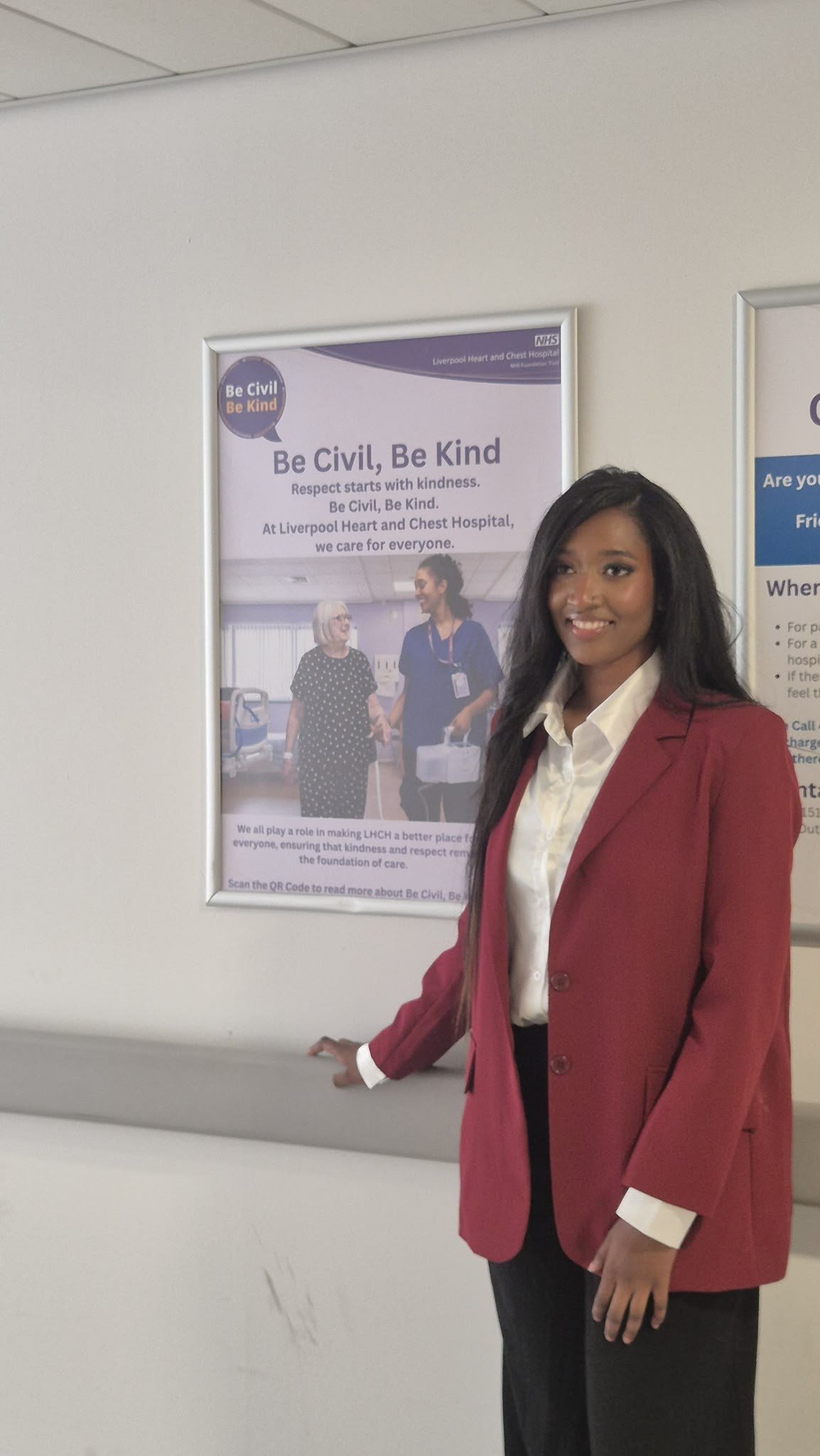 Akiela Malik beside the Be Civil, Be Kind campaign poster